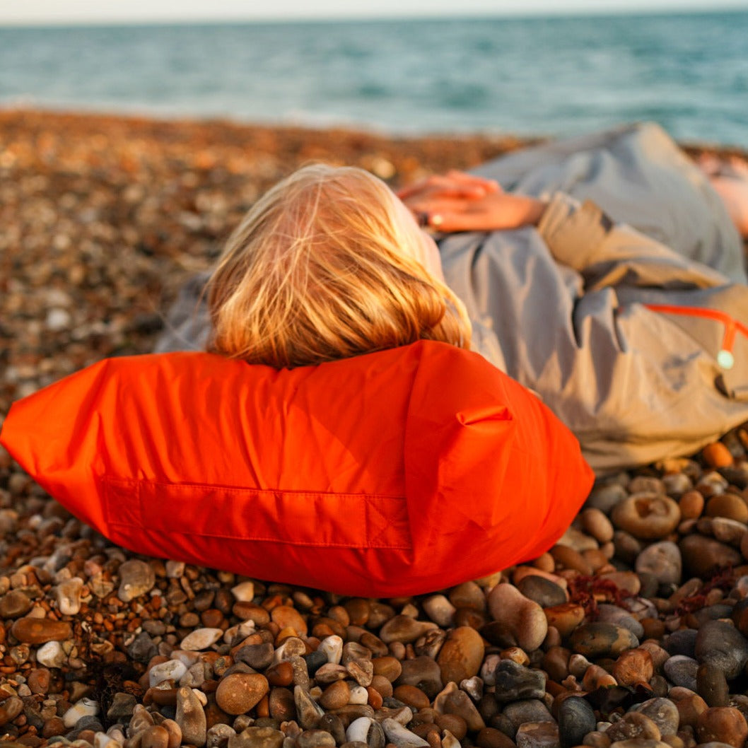 Image showing the ddipp robe packed away and being used as a pillow on the beach