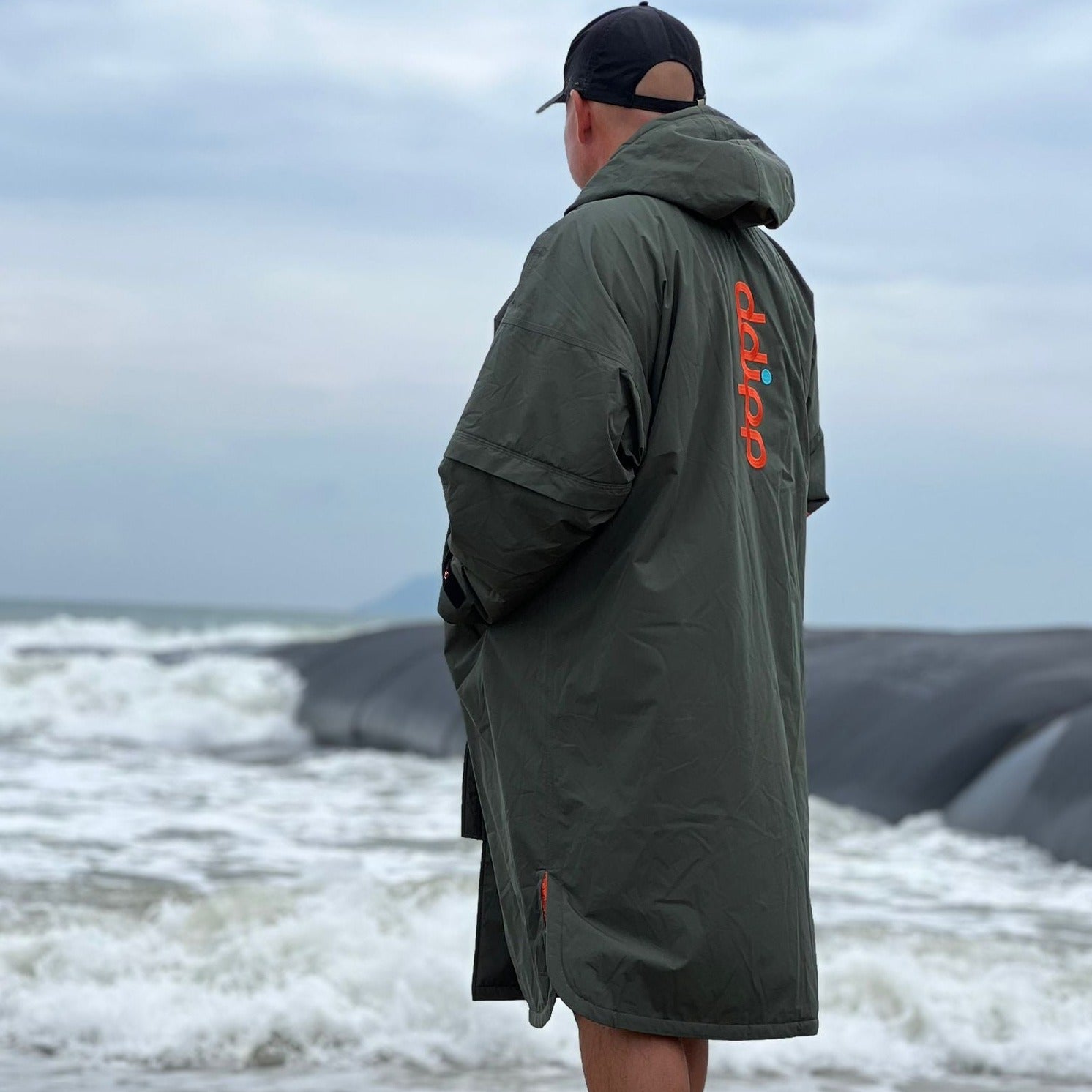 A model wearing the ddipp sports robe in the Olive and Orange Colour way